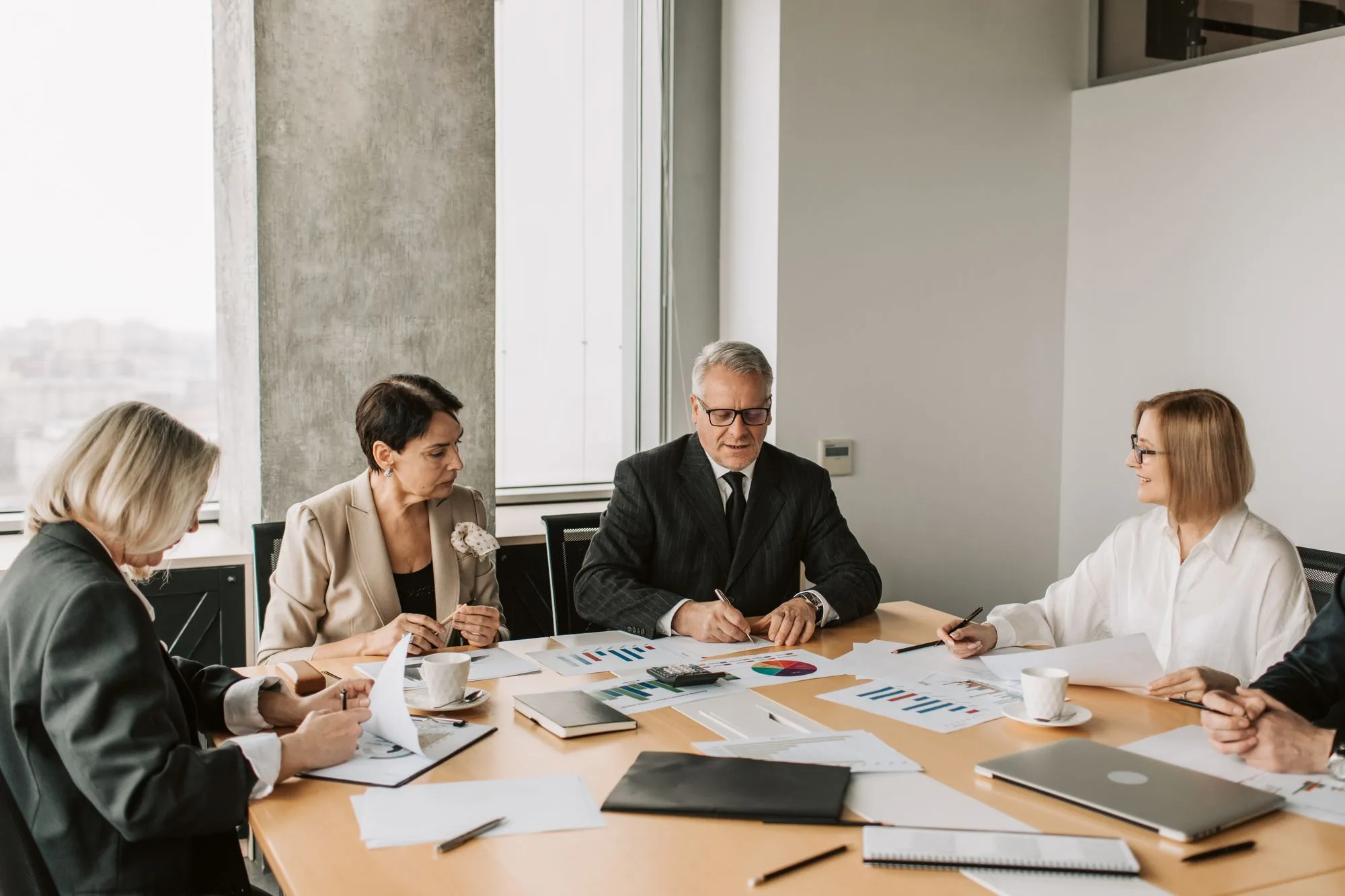 Professionals discussing documents around a conference table.